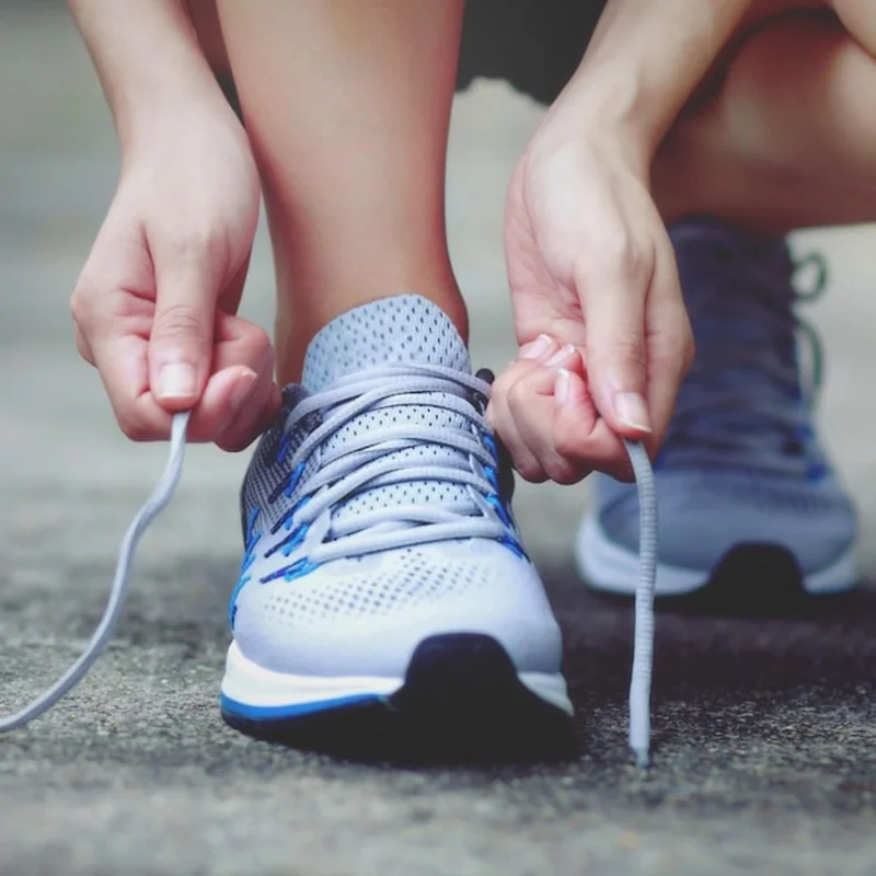 Osoba wiążąca buta na drodze