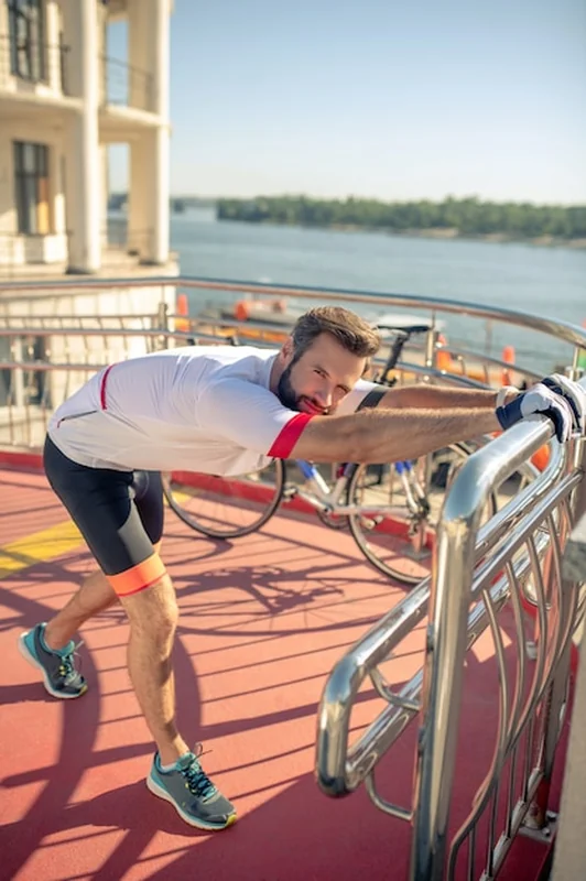 Mężczyzna w odzieży sportowej rozciągający się na ulicy