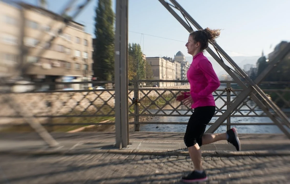 Kobieta biegająca po chodniku o wschodzie słońca
