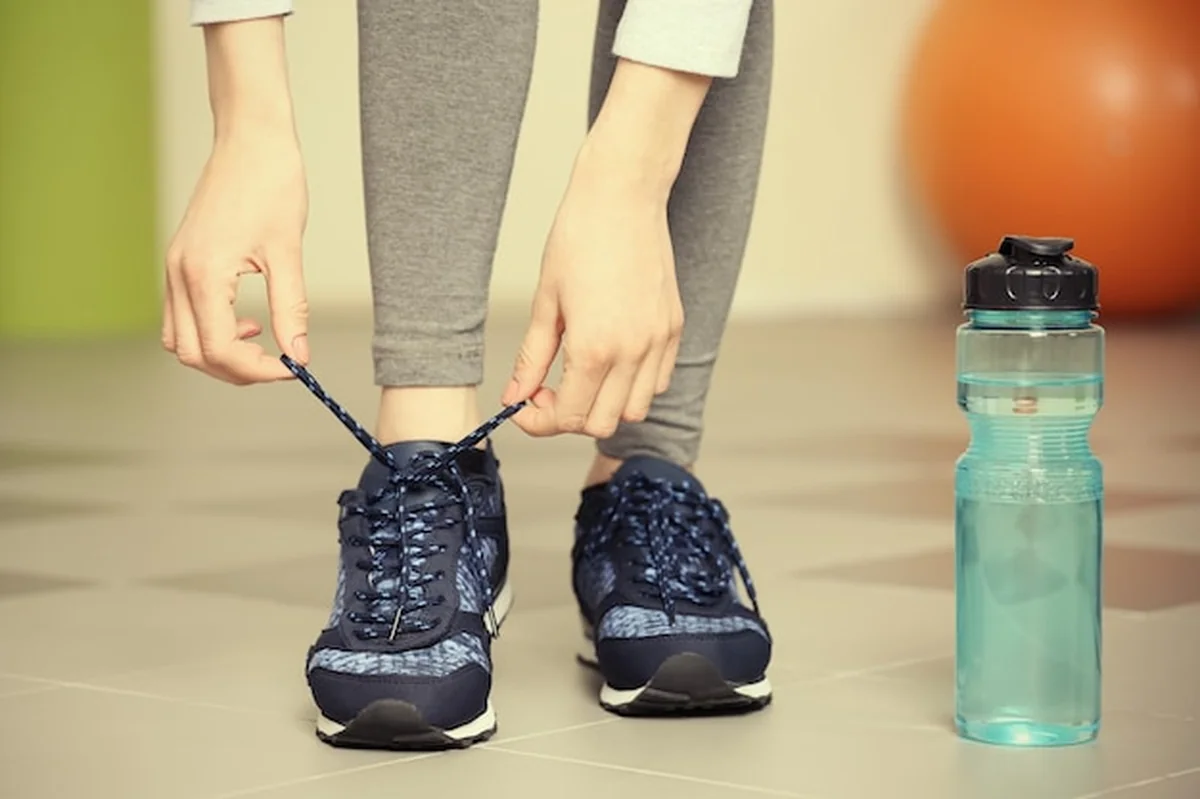 Kobieta wiąże buty do biegania