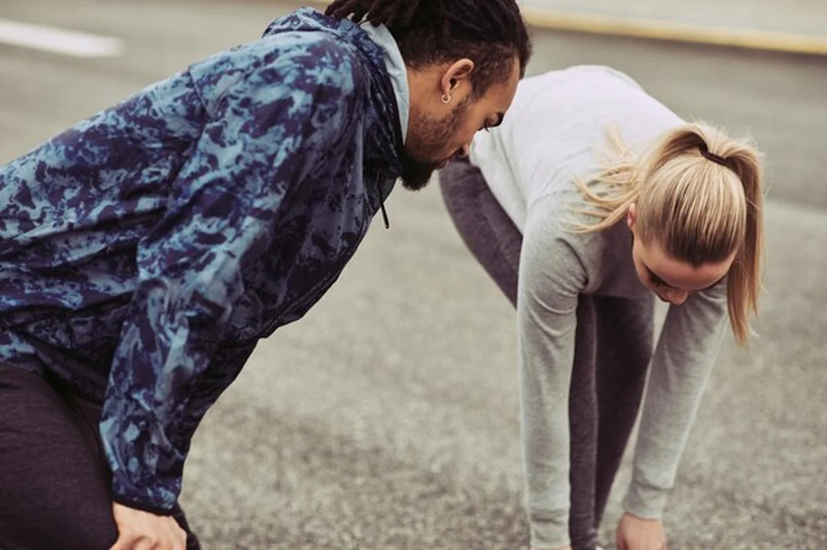 Młoda para w odzieży sportowej przygotowuje się do biegu