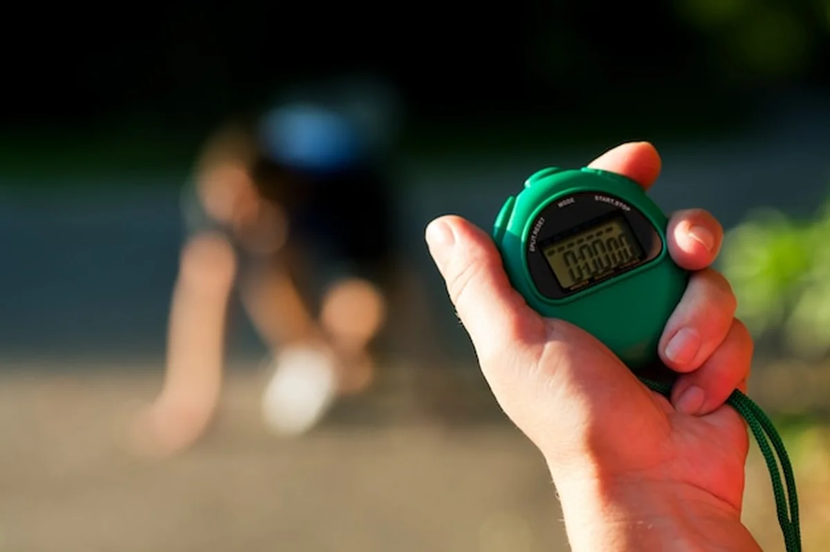 Trener mierzący czas biegacza