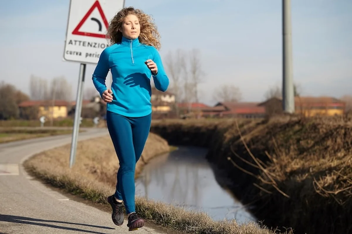 Kobieta biegnie po drodze przeciwko niebu